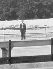Figure standing on spillway catwalk